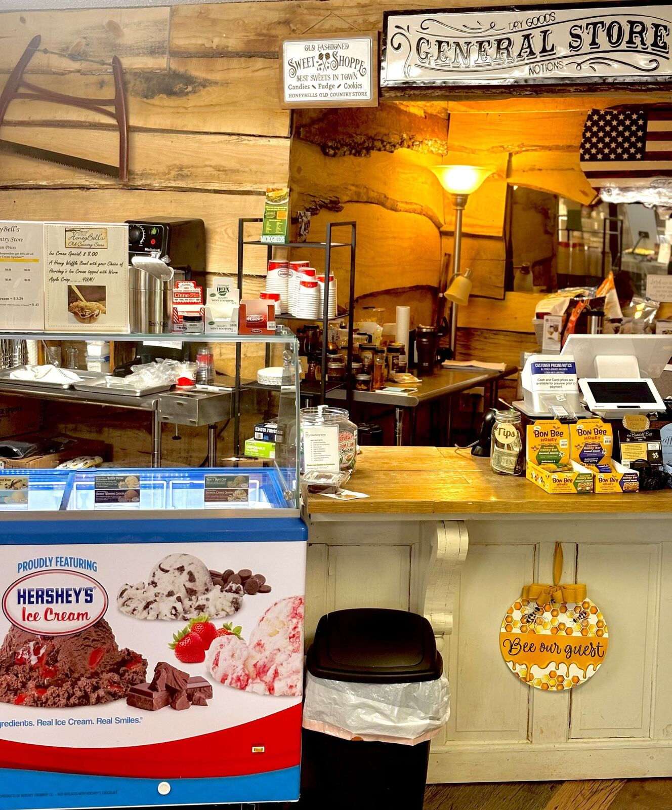 The store counter, with a Hershey's ice cream case, a Sweet Shoppe sign, and a General Store sign on a wood-plank wall