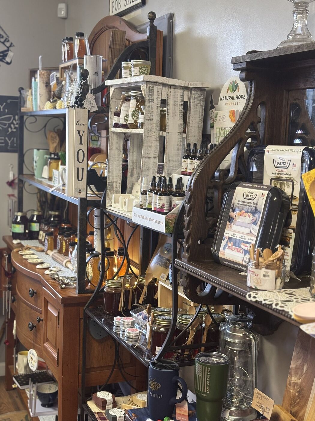 Shelves of honey jars, herbal tinctures, and bee-themed gifts inside the store